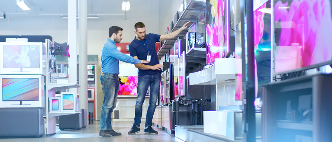 retail worker showing flat screens to customer