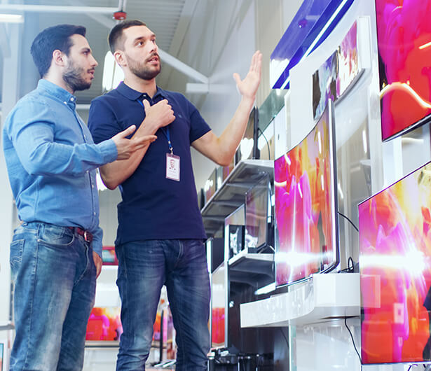 Retail worker showing tv's to a potential customer