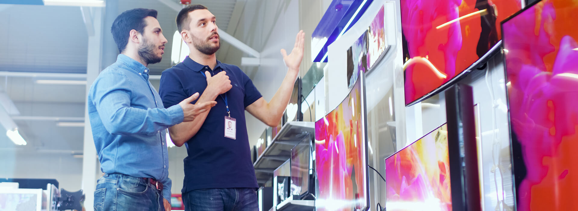 Retail employee showing customer tvs